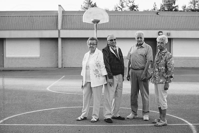 Funny portrait of grumpy caucasian seniors outside at schoolyard basketball courts