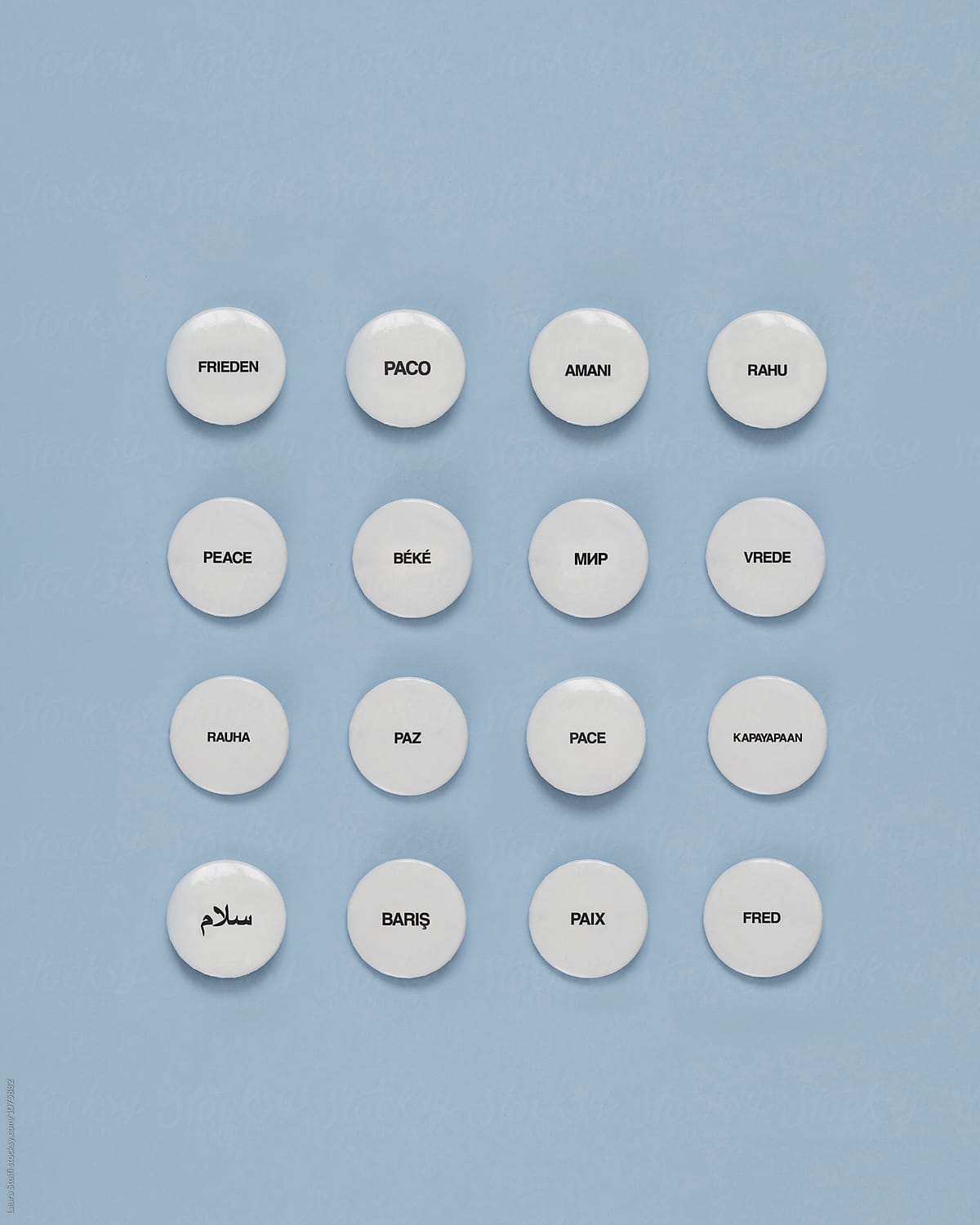16 pins spelling the word PEACE in different languages