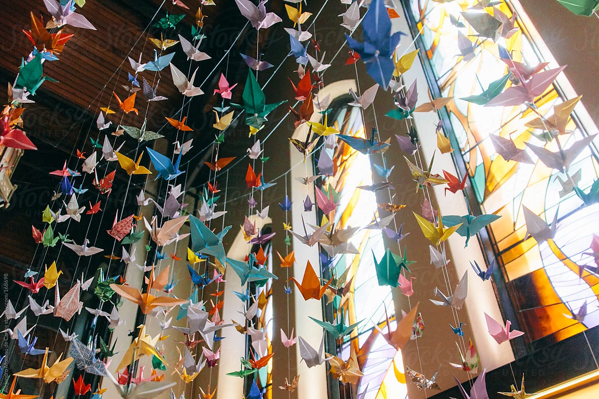 Colorful origami cranes suspended. Paper folding craft