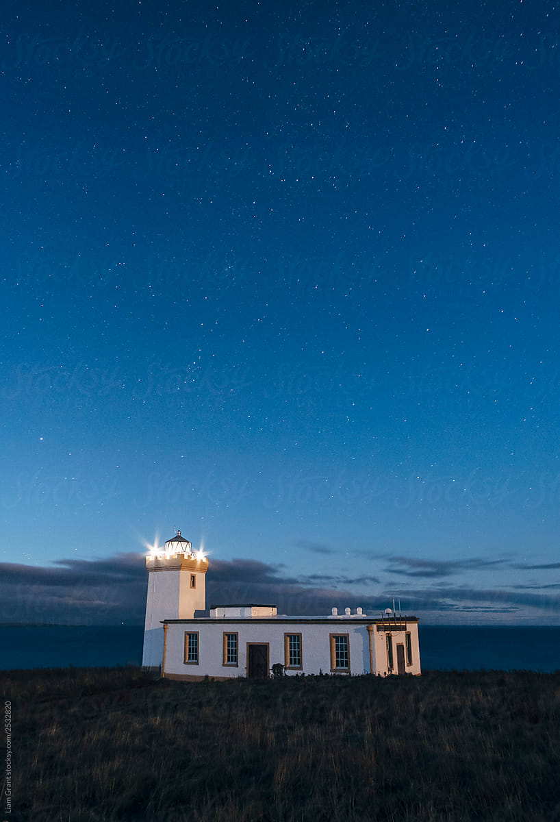 Stars over lighthouse at Duncansby Head. Highlands, Scotland, UK