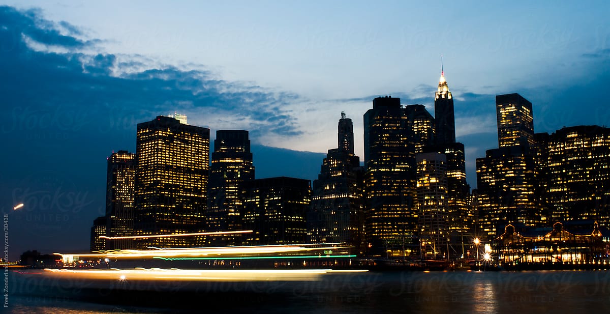 Boat passing Manhattan during magic hour