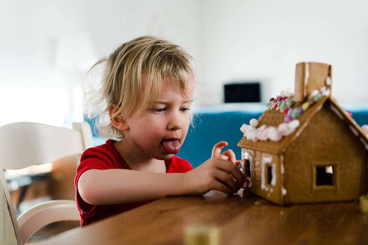 toddler girl decorating gingerbread houses