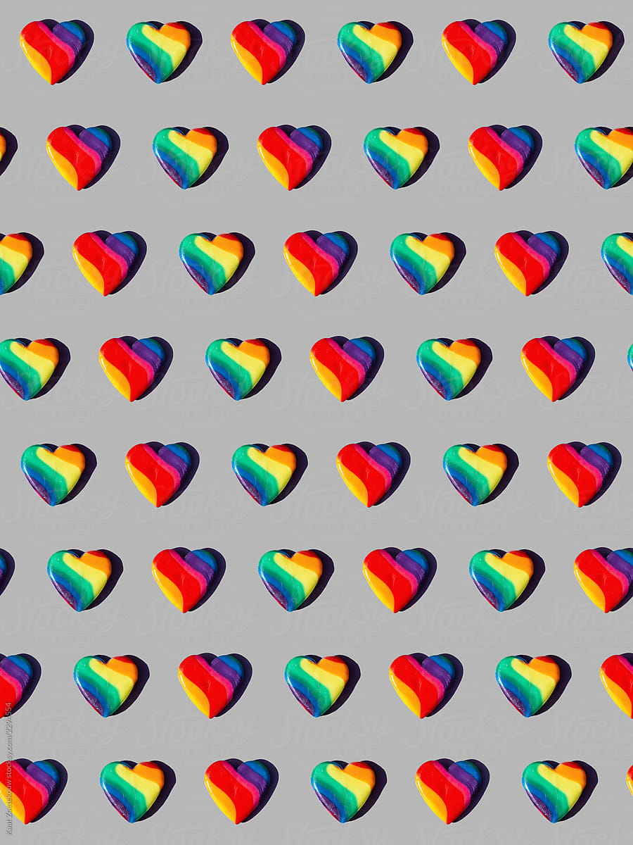 Rainbow-colored candy hearts patterned on grey