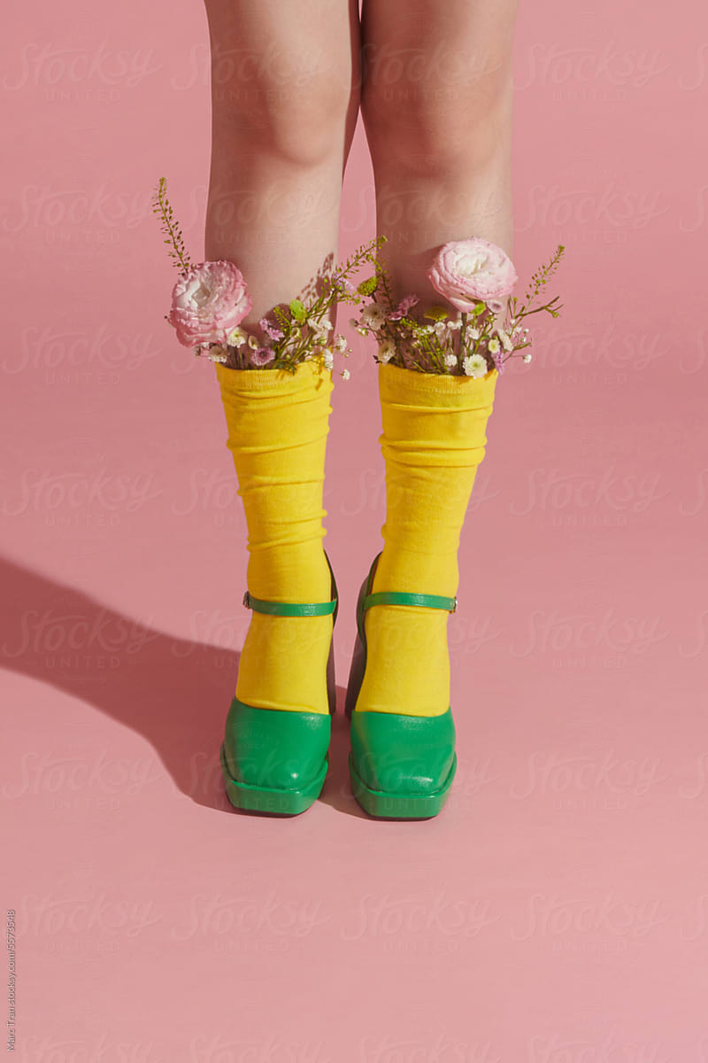 Unrecognizable female in stylish sandals with a bunch of fresh flowers