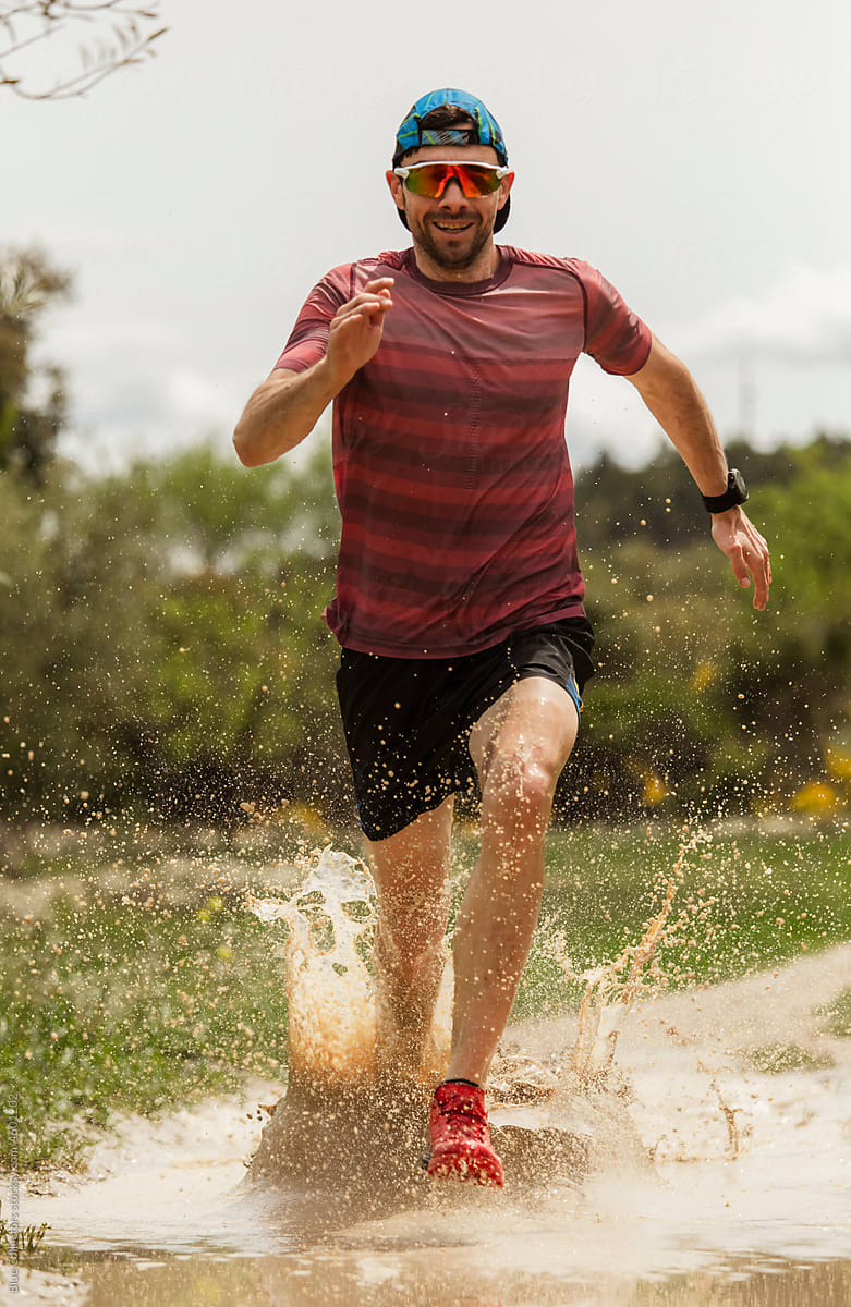 runner splashes on muddy track