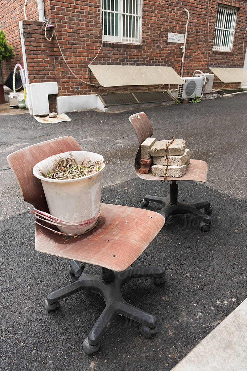 Flower pot and bricks on the each of chairs