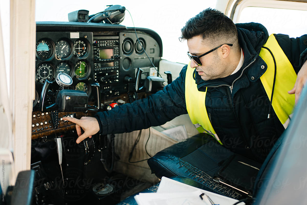 Male engineer examining light plane  on airfield