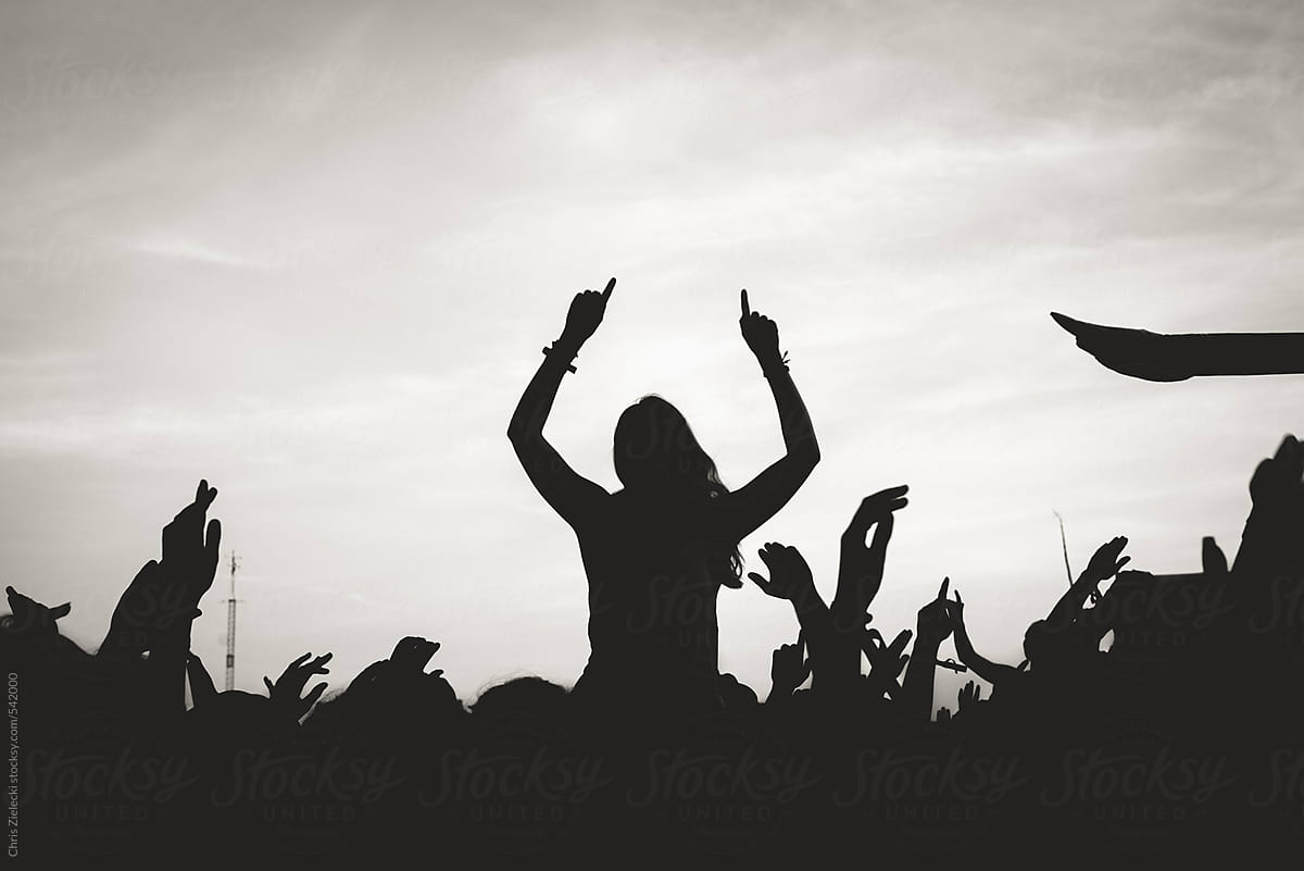 Silhouettes of people enjoying music on festival and dancing