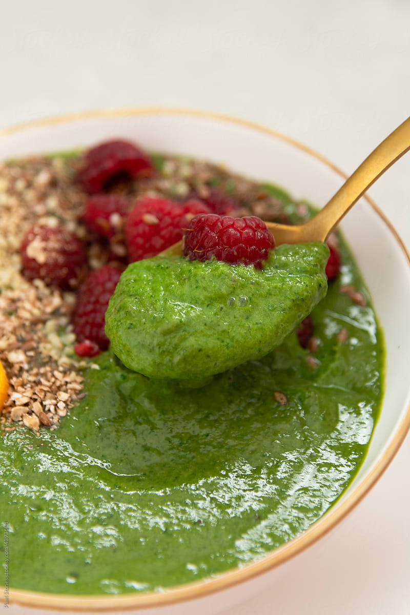 Eating spinach and kiwi detox breakfast smoothie bowl
