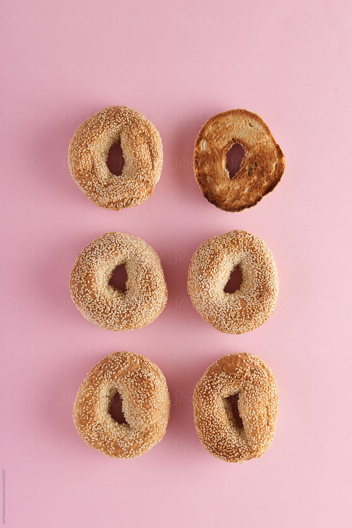 Sesame Seed Bagels on Pink with One Toasted
