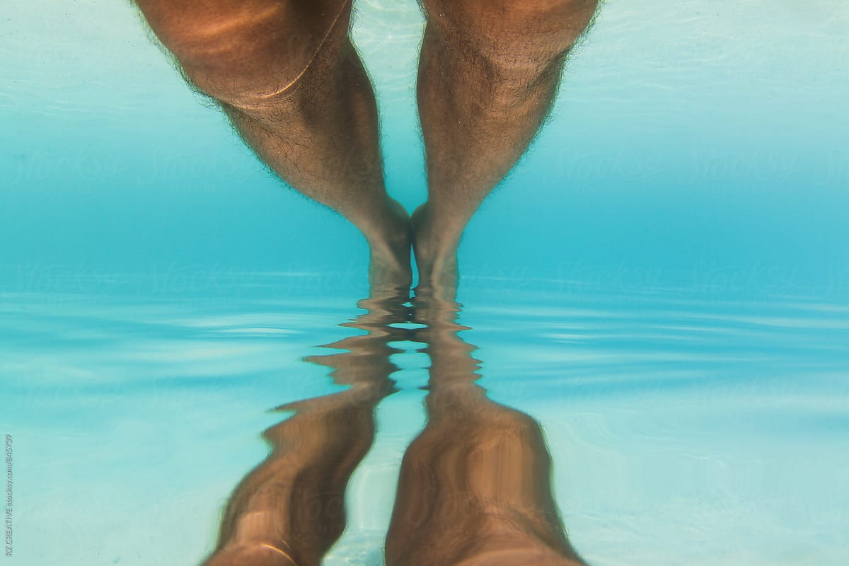 Underwater reflection of a man\'s legs.
