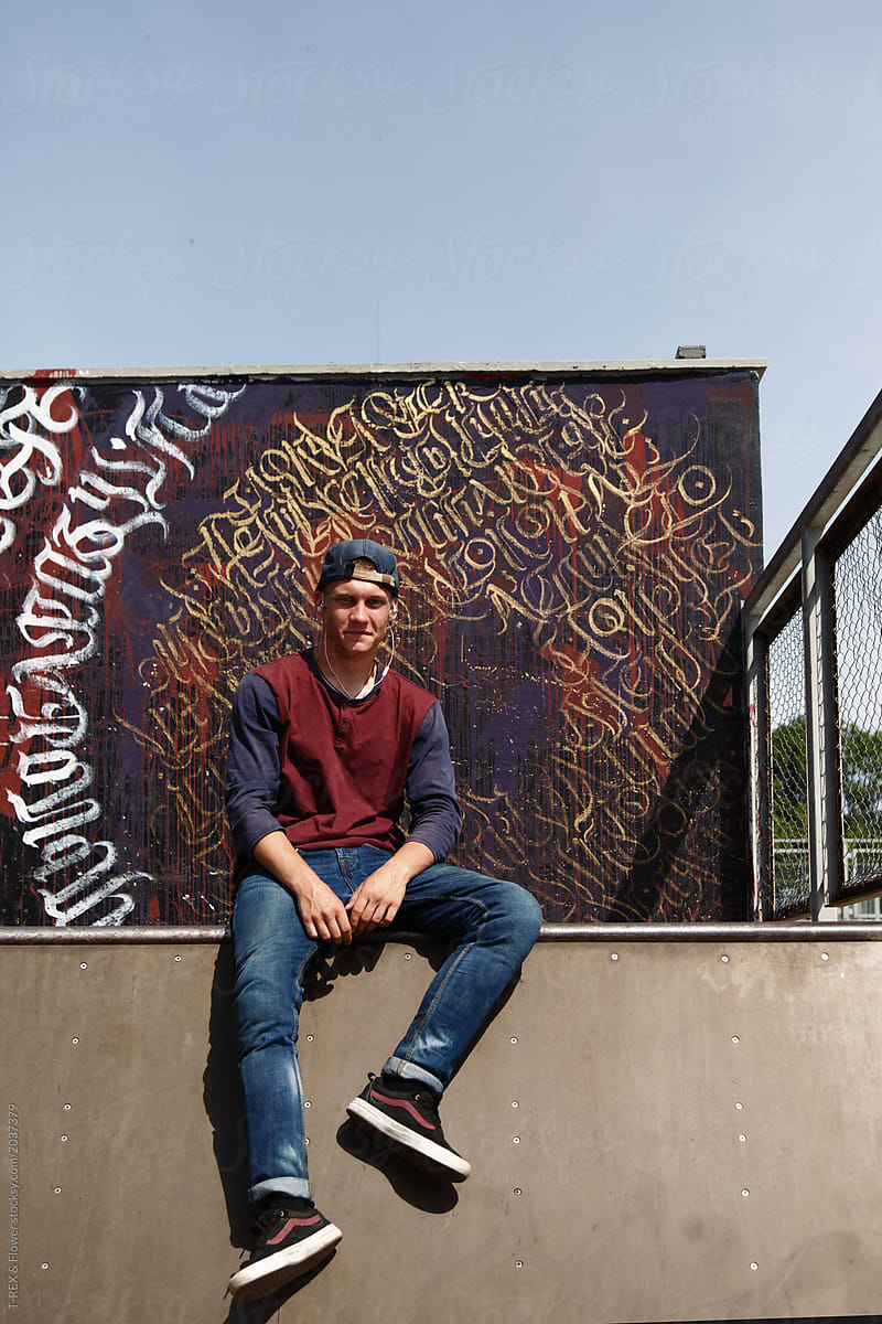 Casual teenager sitting at graffiti