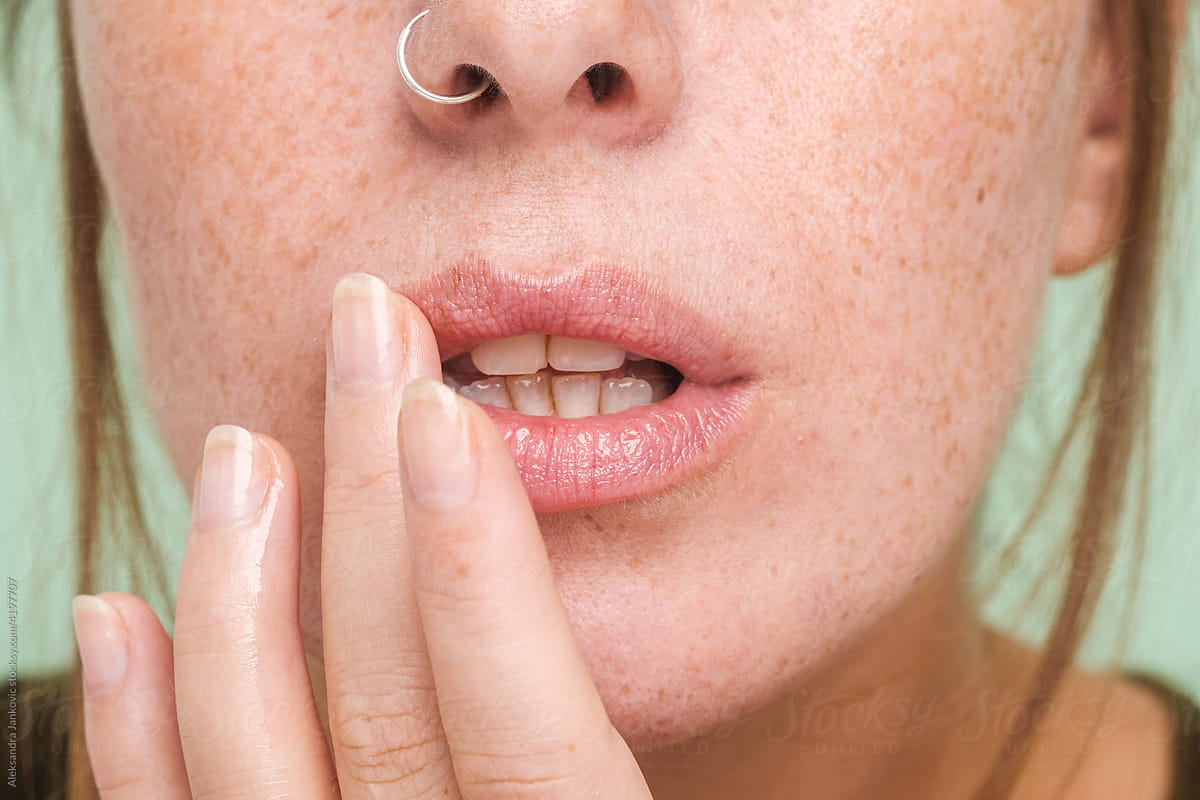 Anonymous Woman With Freckles Applying Lip Balm