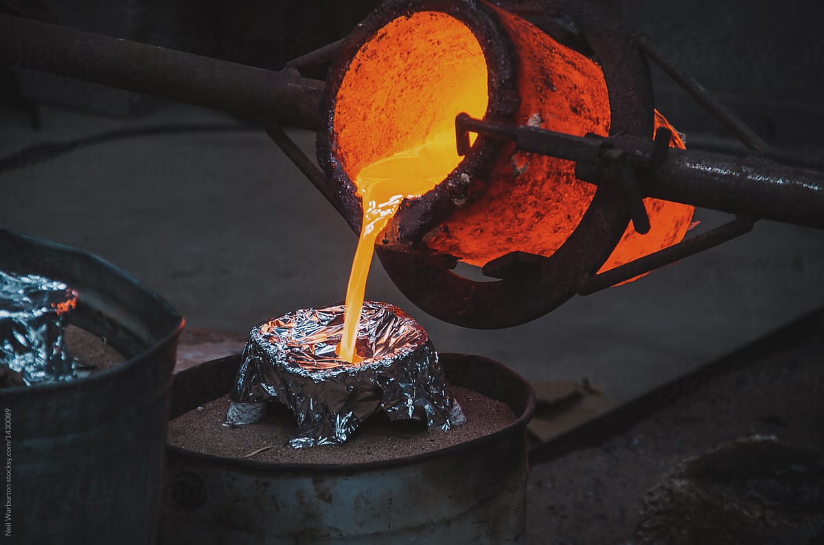 Pouring molten bronze into ceramic shell