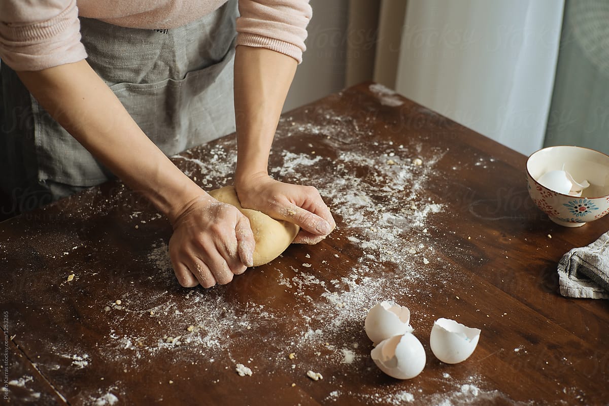 Person in kitchen making dough