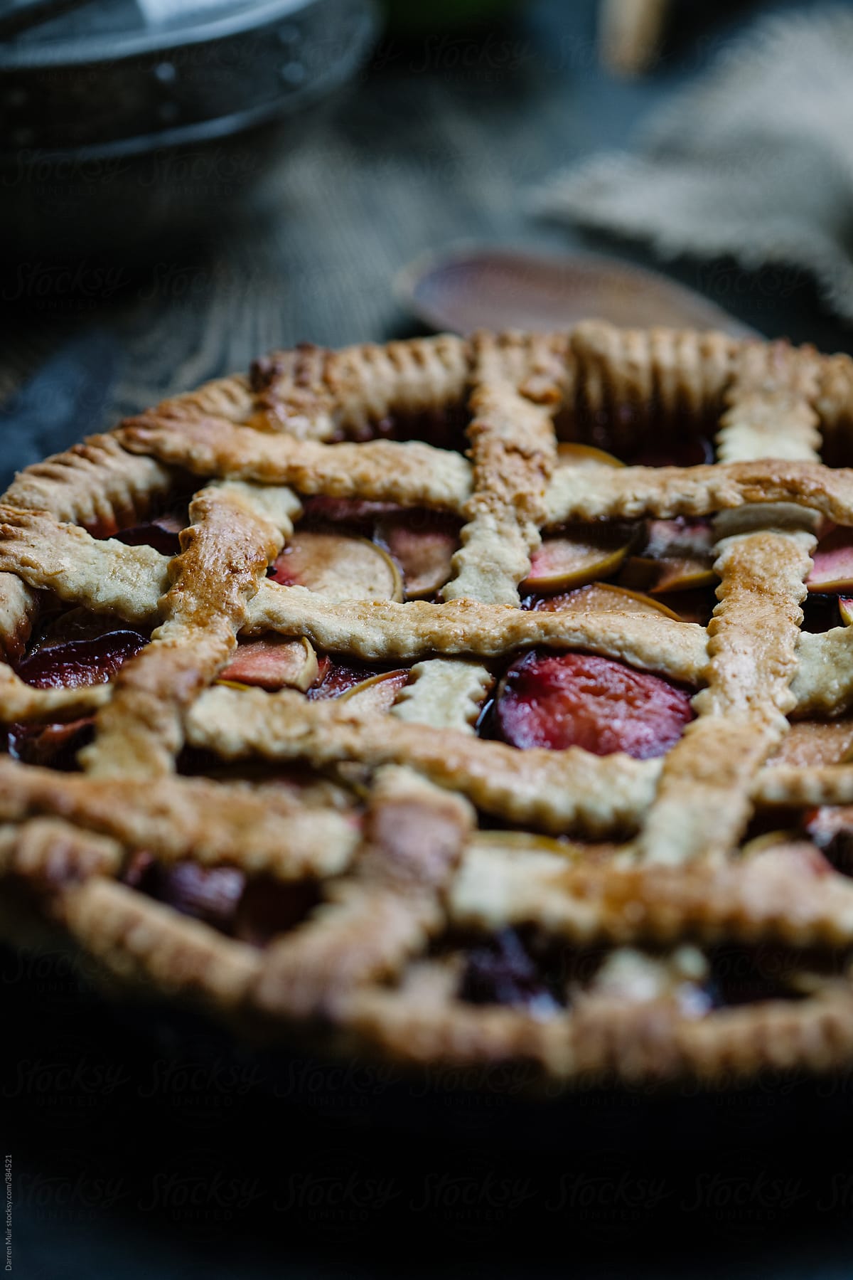 Homemade apple and plum pie on table closeup.