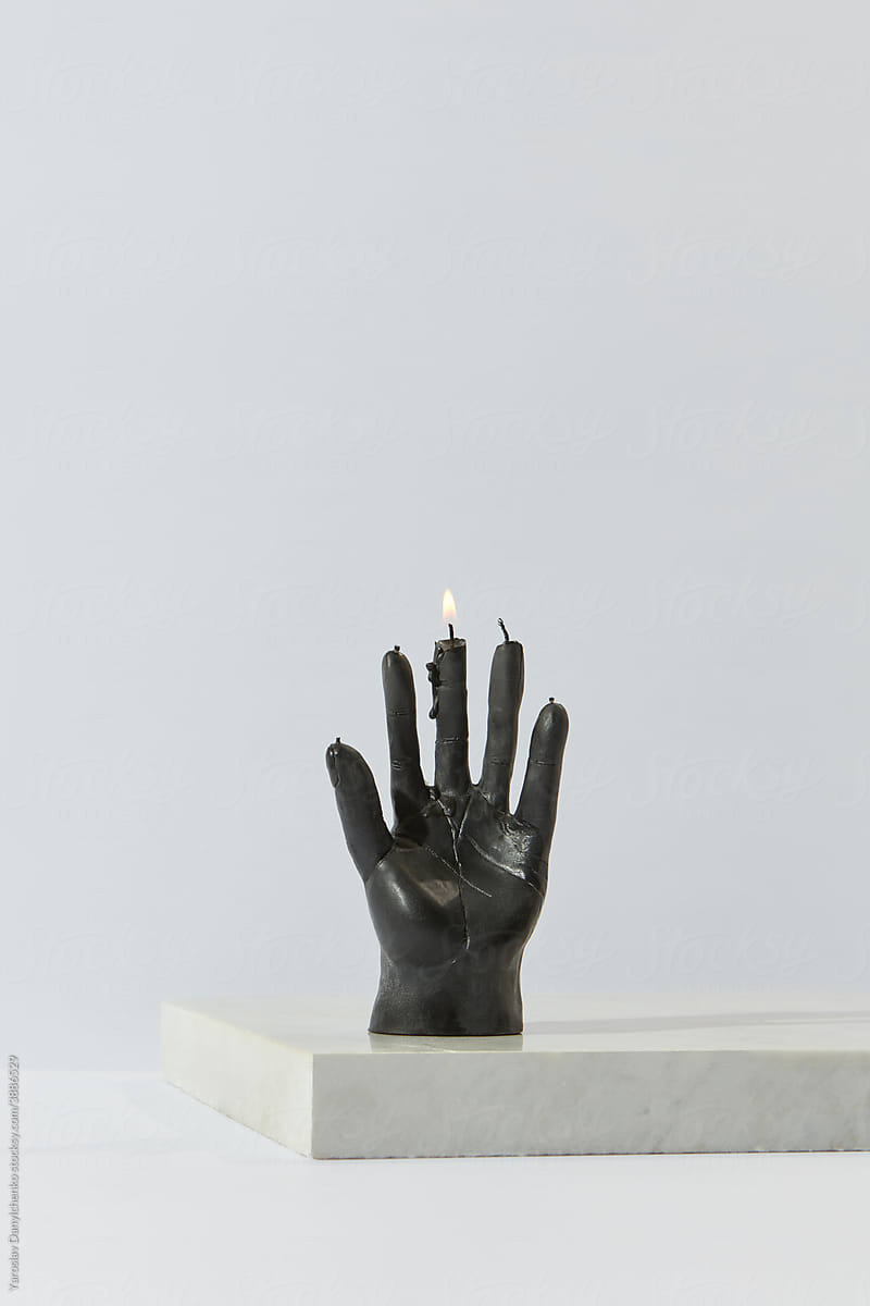 Black candle in shape of human hand