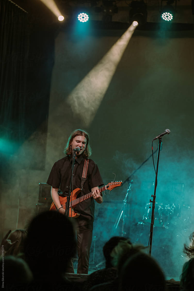 A rock artist with a guitar performs at a concert