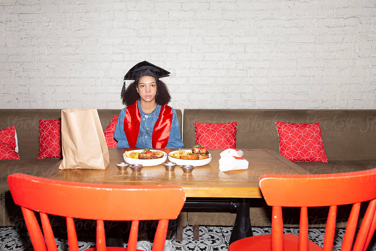 Emotionless graduate student sitting alone in cafe