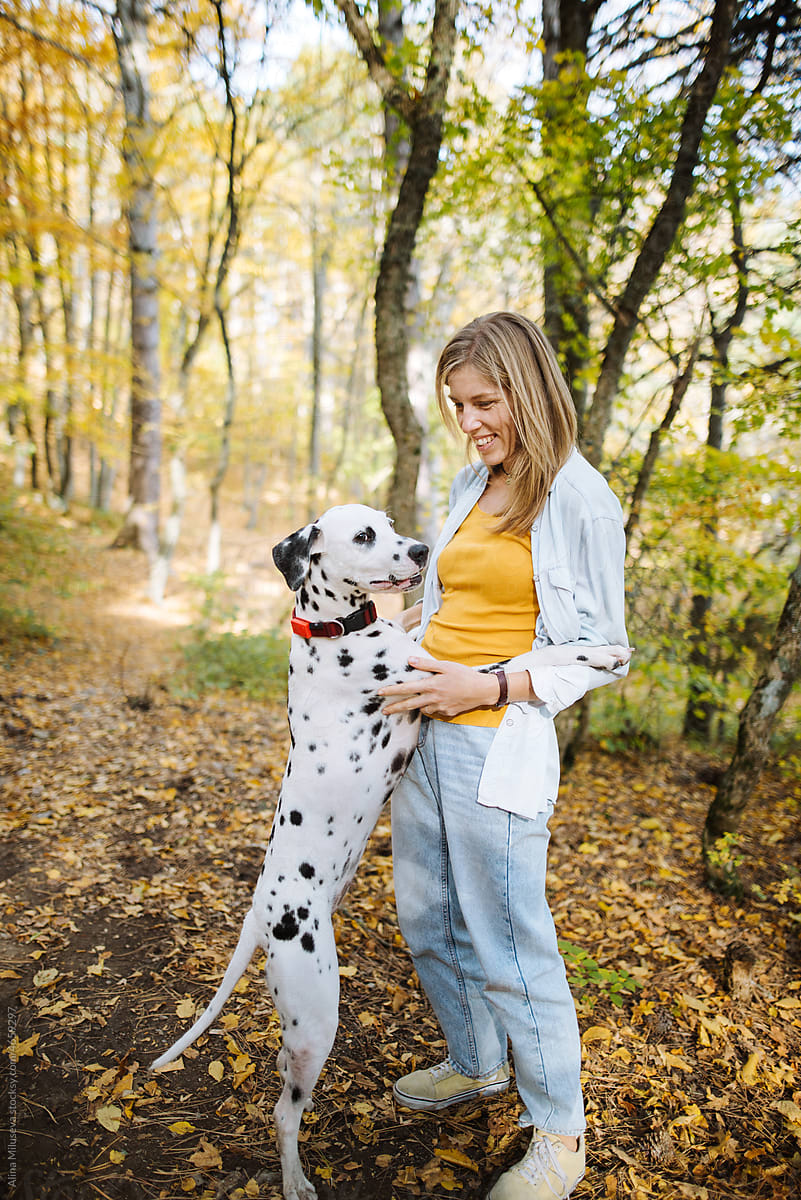 Happy woman with dog in autumn park