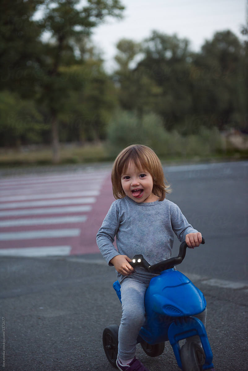 Portrait of young girl riding blue scooter