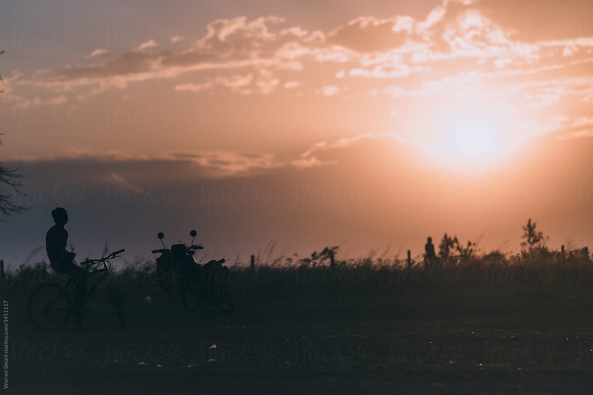 A local Malawian watches the sunset from his motorbike.
