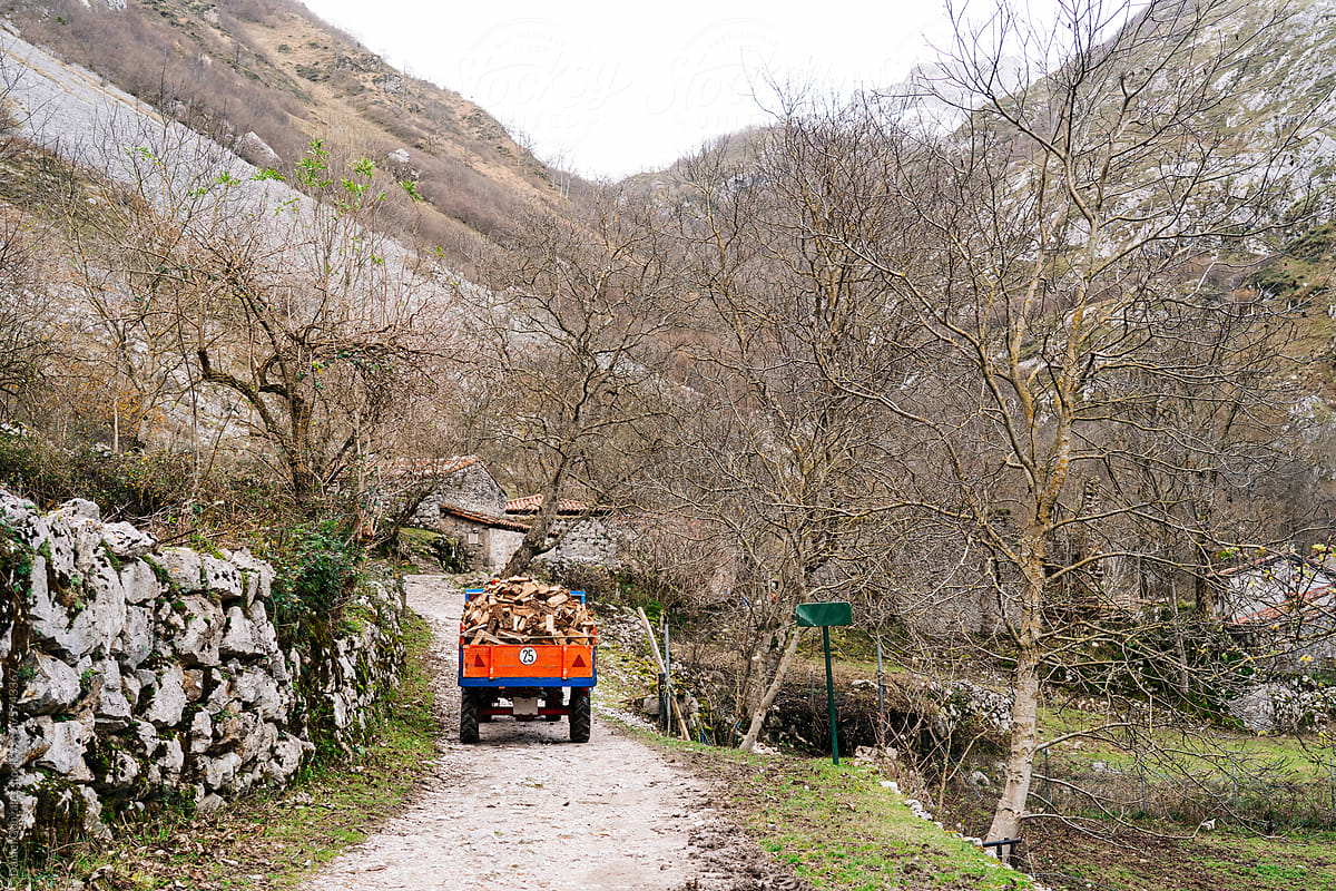 Old truck with firewood riding on pathway in mountains