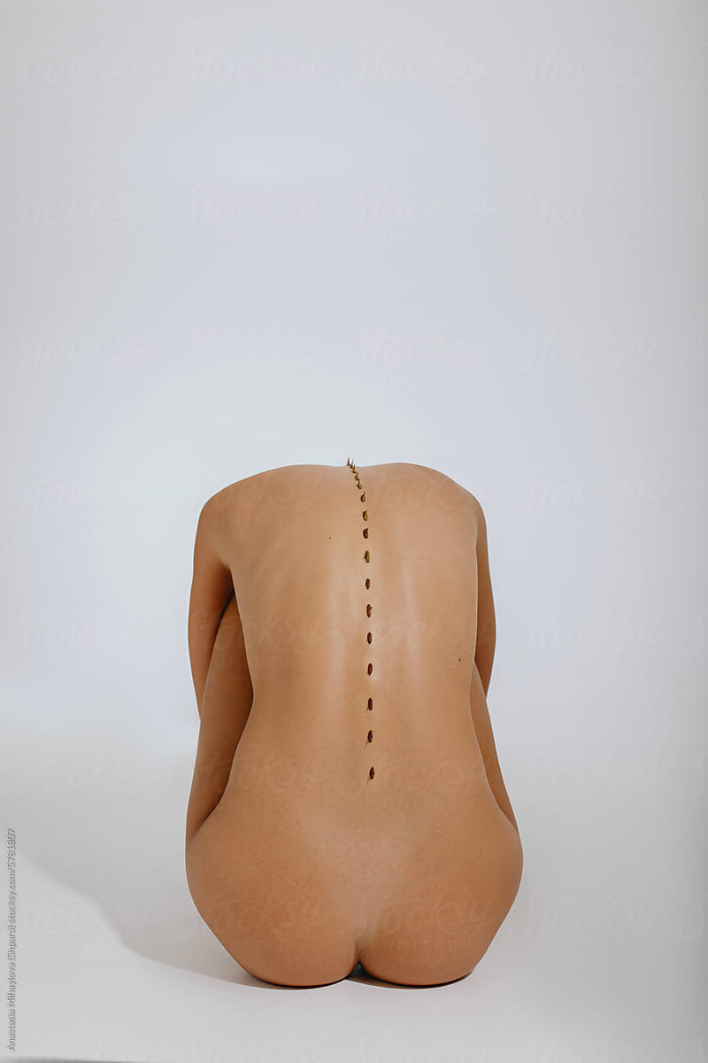 Close up photo of naked woman\'s skin of the back with thorns on spine