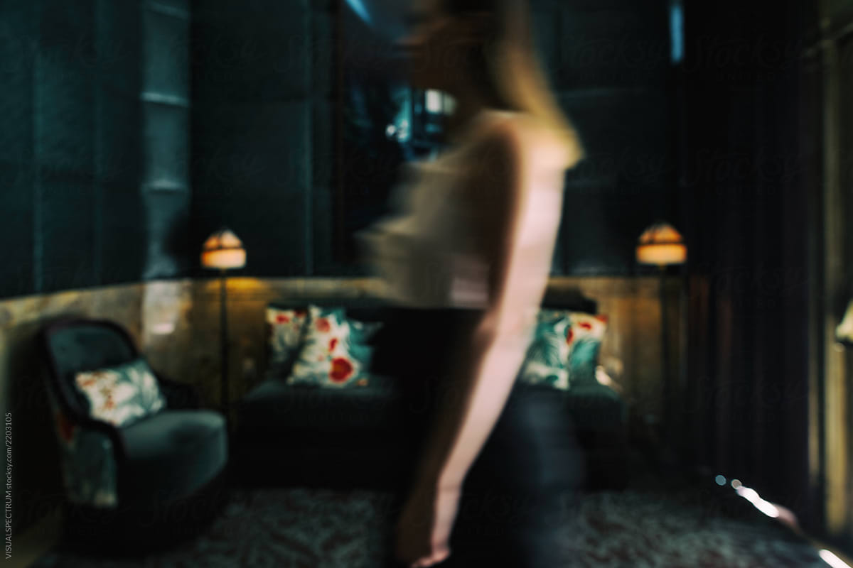 Motion Blur of Woman Walking Through Hotel Dark Green Hotel Lobby