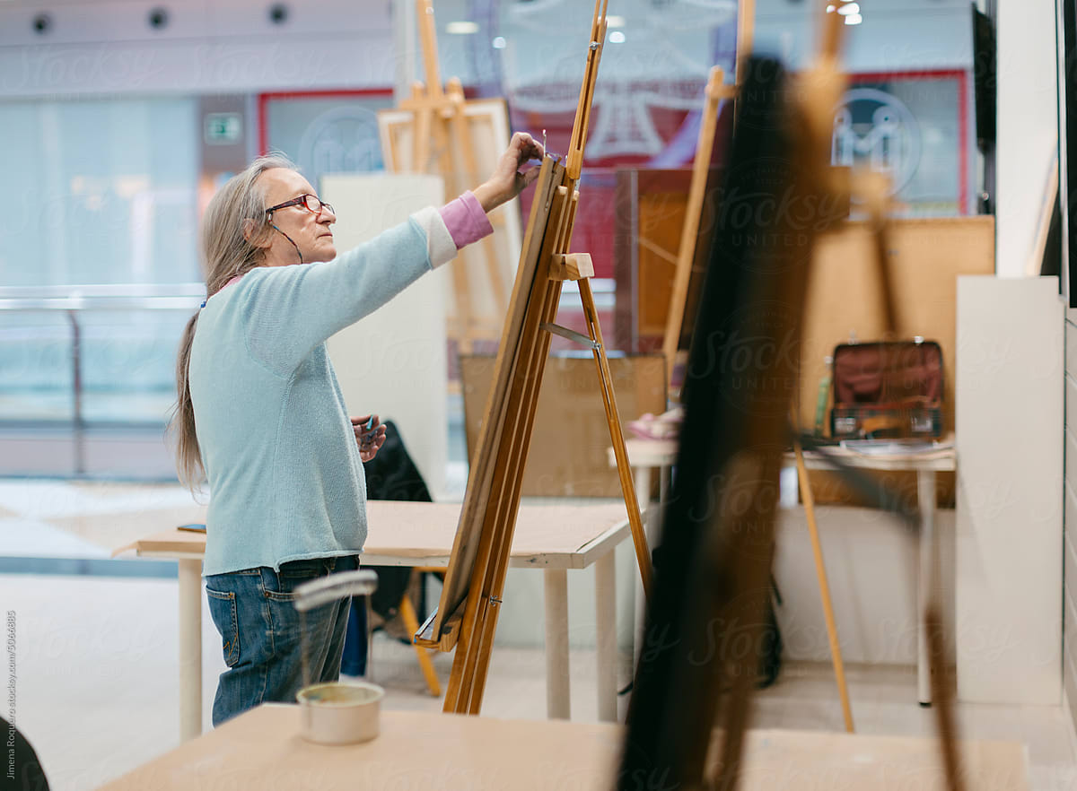 Woman painting with pastel technique in art school studio