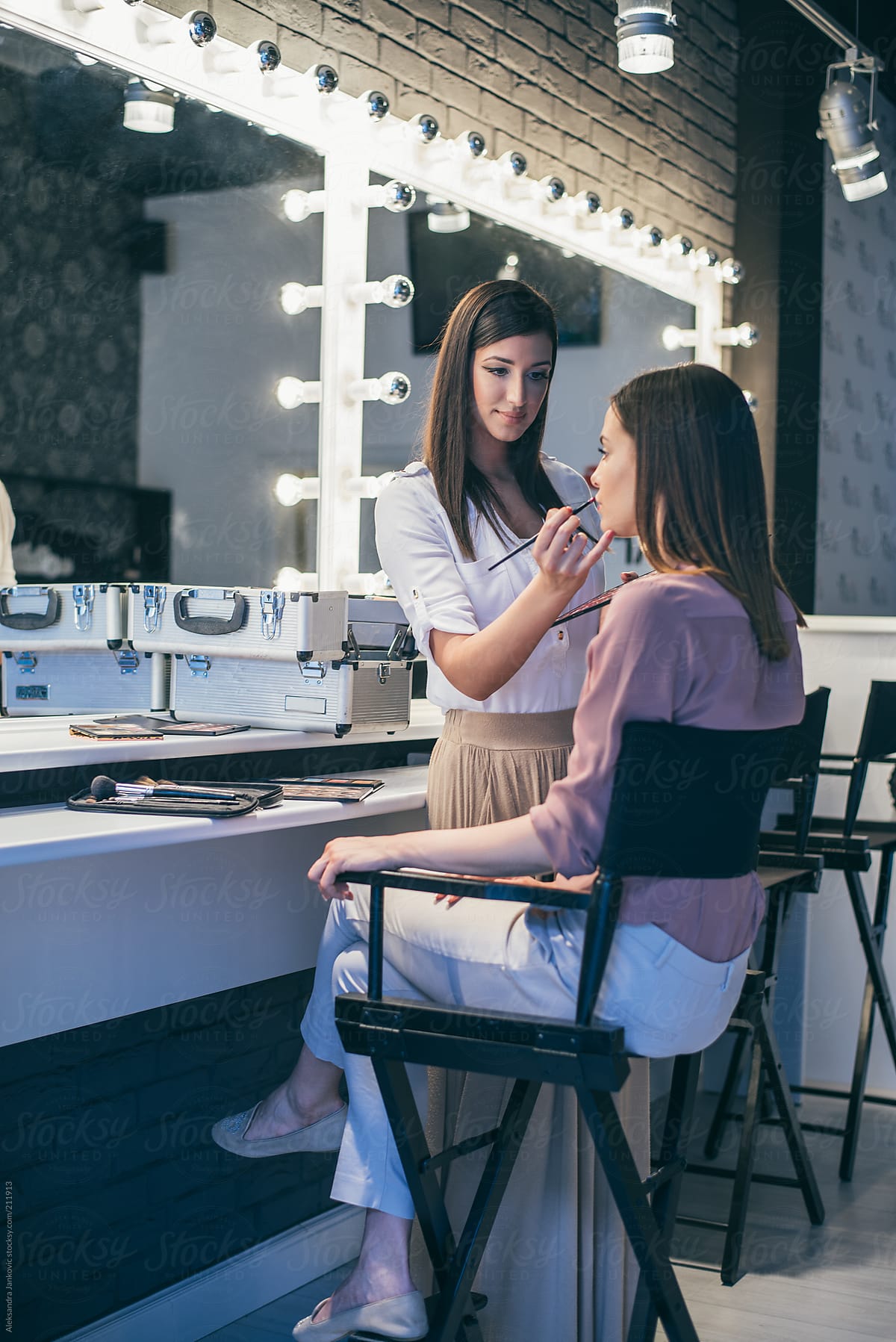 Female makeup artist applying makeup on her client at salon
