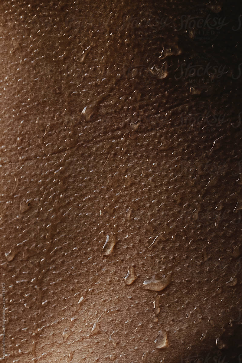 Detail-Close up tanned skin texture with water drops