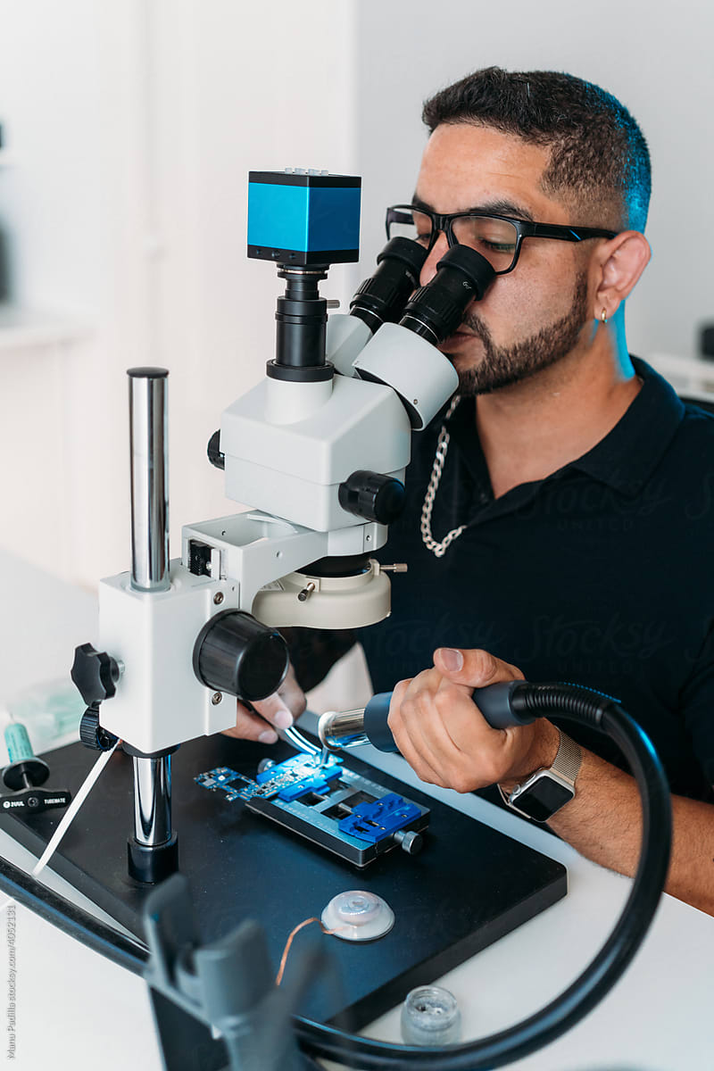 Man detaching microchip under microscope
