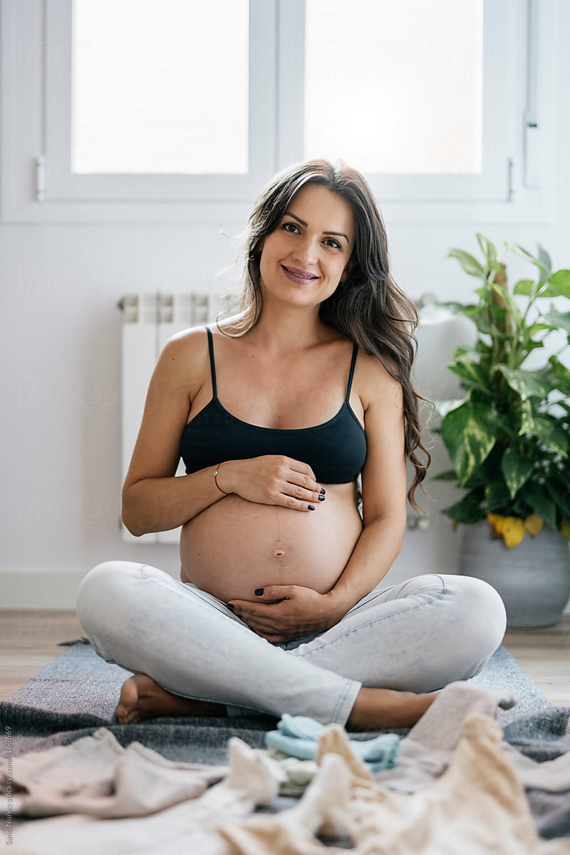 Portrait of smiling pregnant woman at home