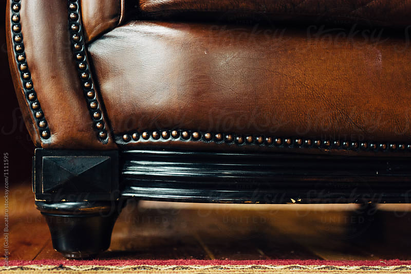Wooden foot on a leather sofa