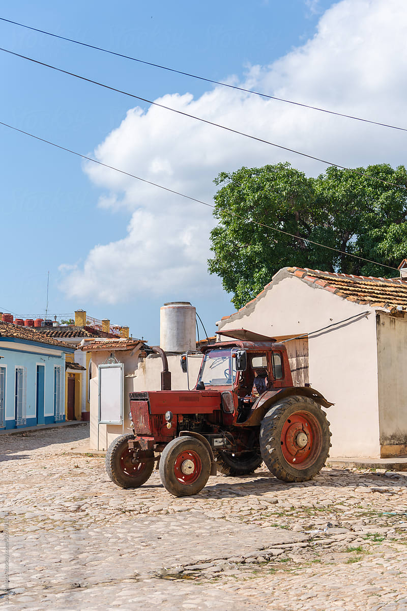 A Red Tractor Parked On A Cobbled Street