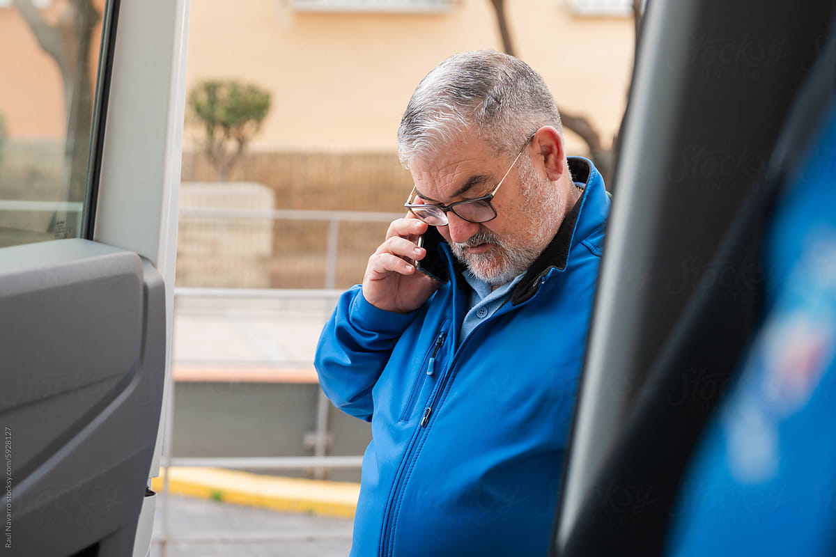 portrait of a man talking on the phone in blue uniform.