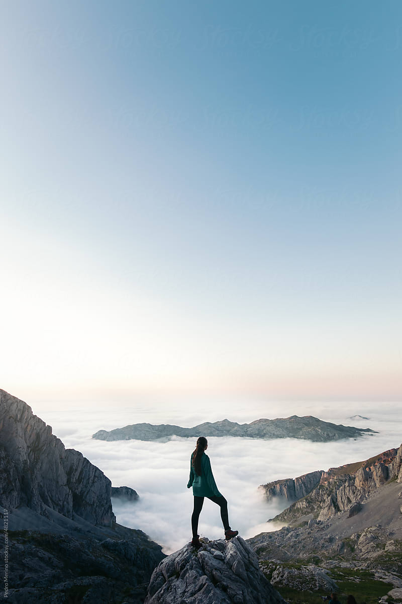 Hiker above a sea of clouds in the mountains