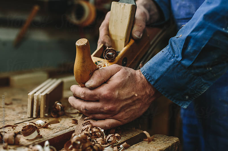 detail of a woodworker working with his wood plane