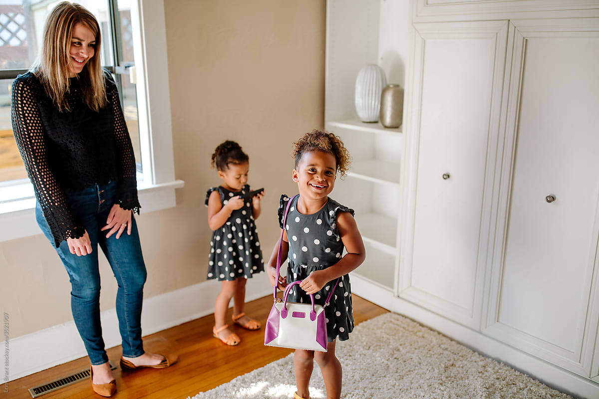 Smiling mother and biracial daughters take tour of house for sale