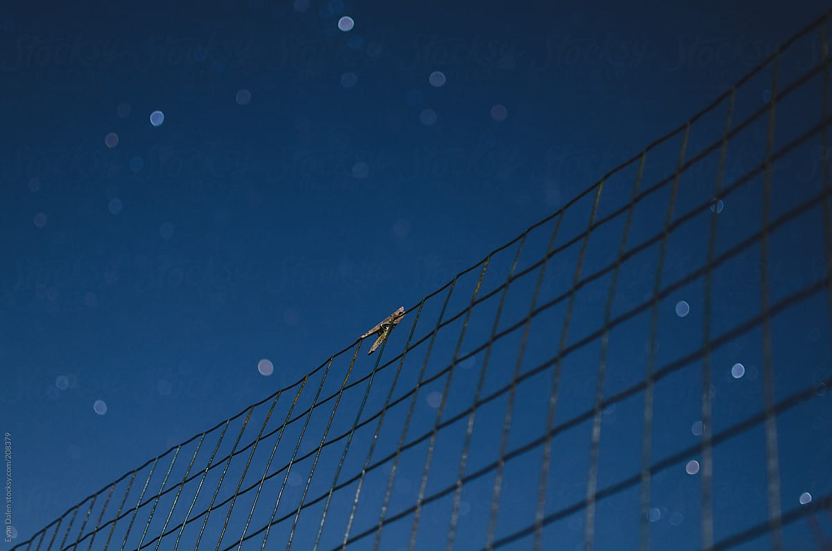 Clothing pin attached to fence beneath stars