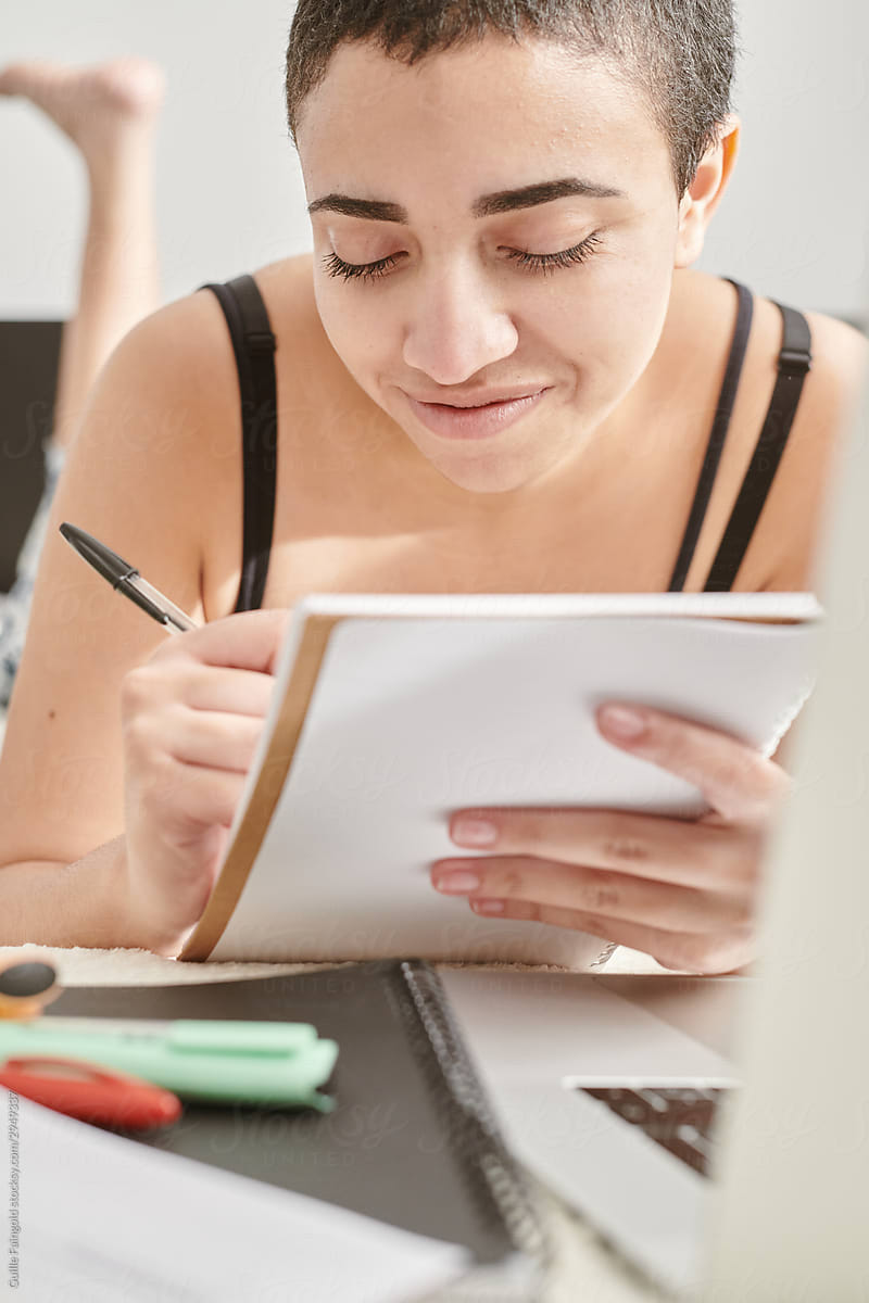 Joyful woman taking notes in notebook