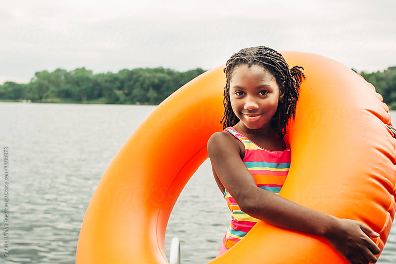 Smiling black girl with orange inner tube