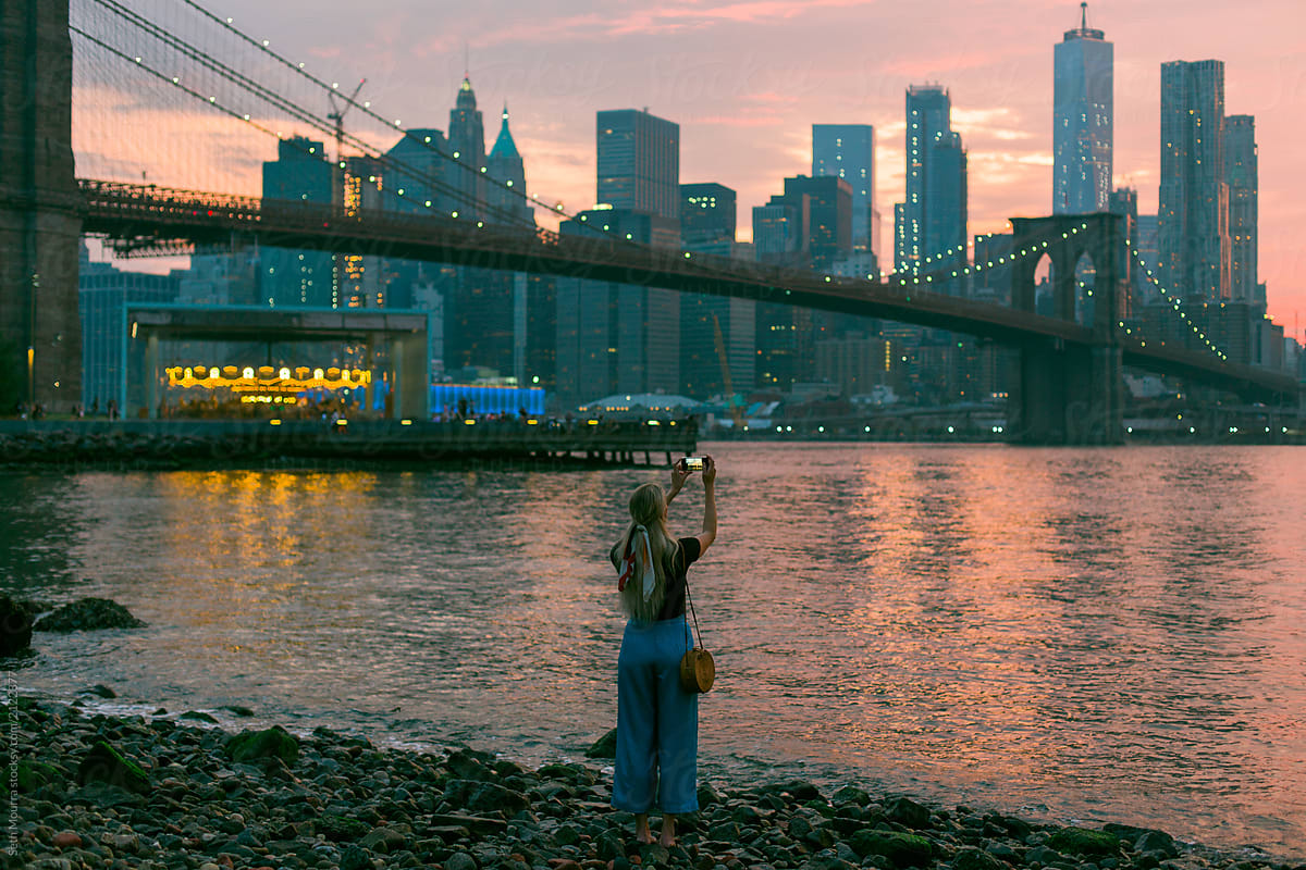 Girl taking a photo of the of Brooklyn Bridge