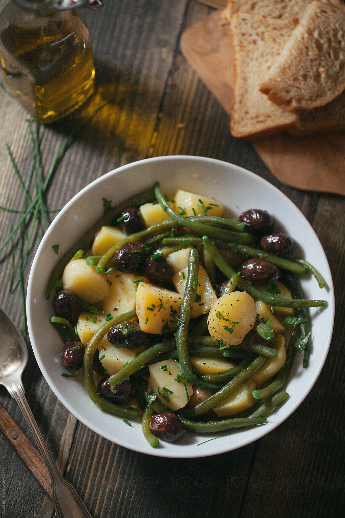 Vegan salad with potatoes green beans and black olives.