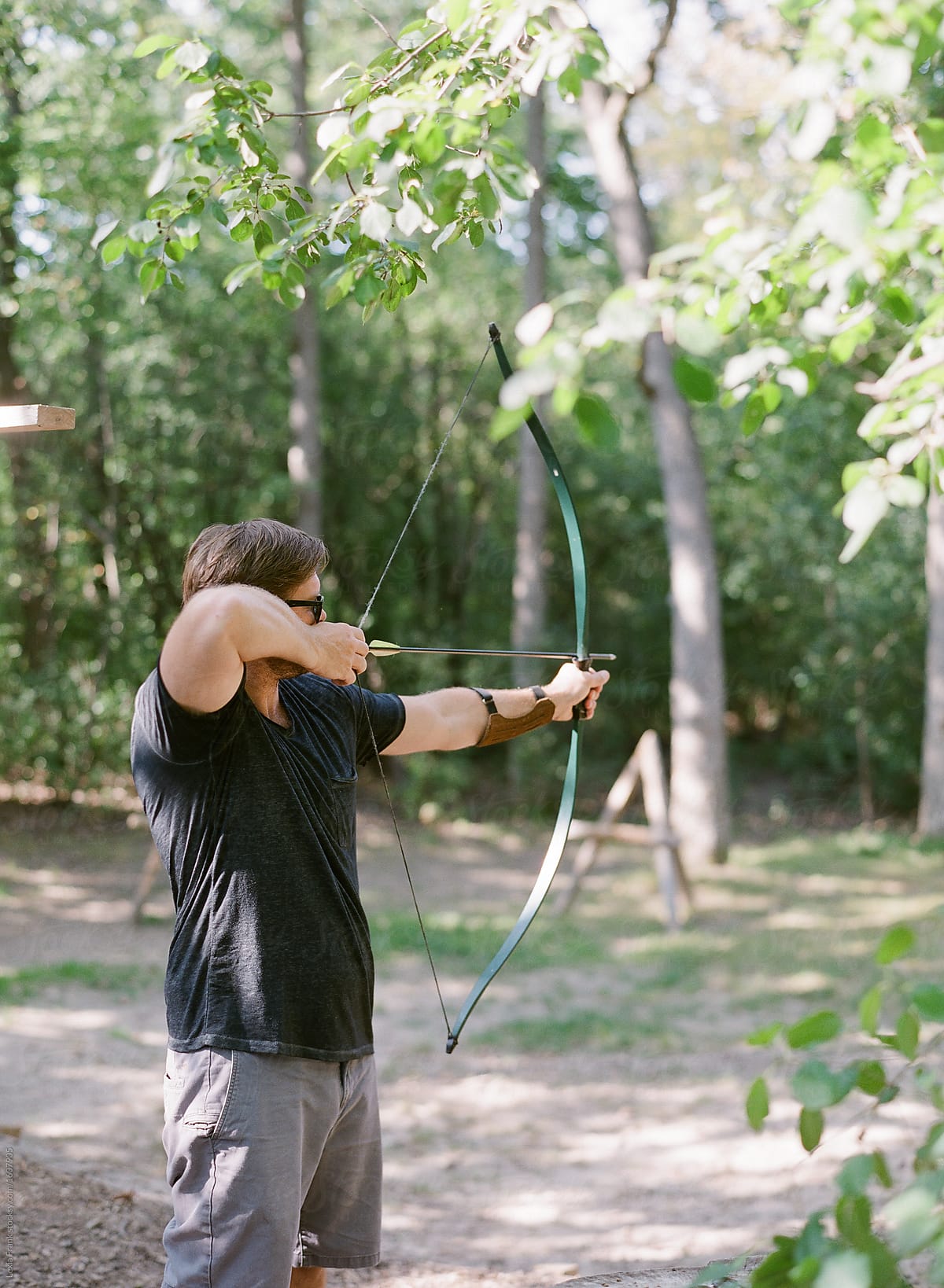 man shooting bow and arrow