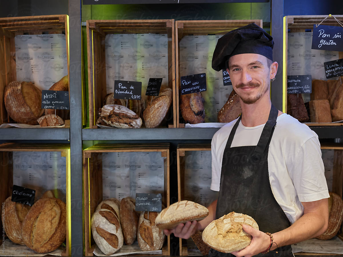 Friendly baker at the counter with all sort of breads
