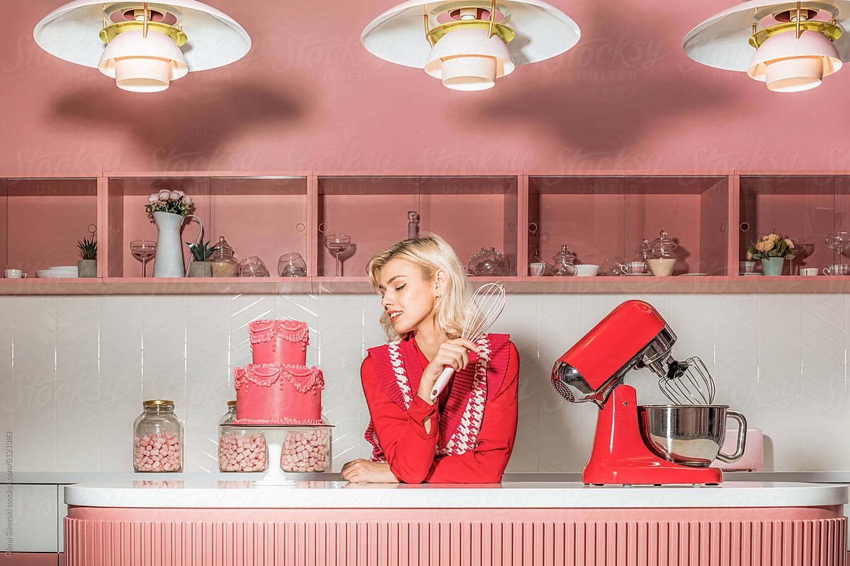 Beautiful blonde in the kitchen with an elegant cake in vintage style