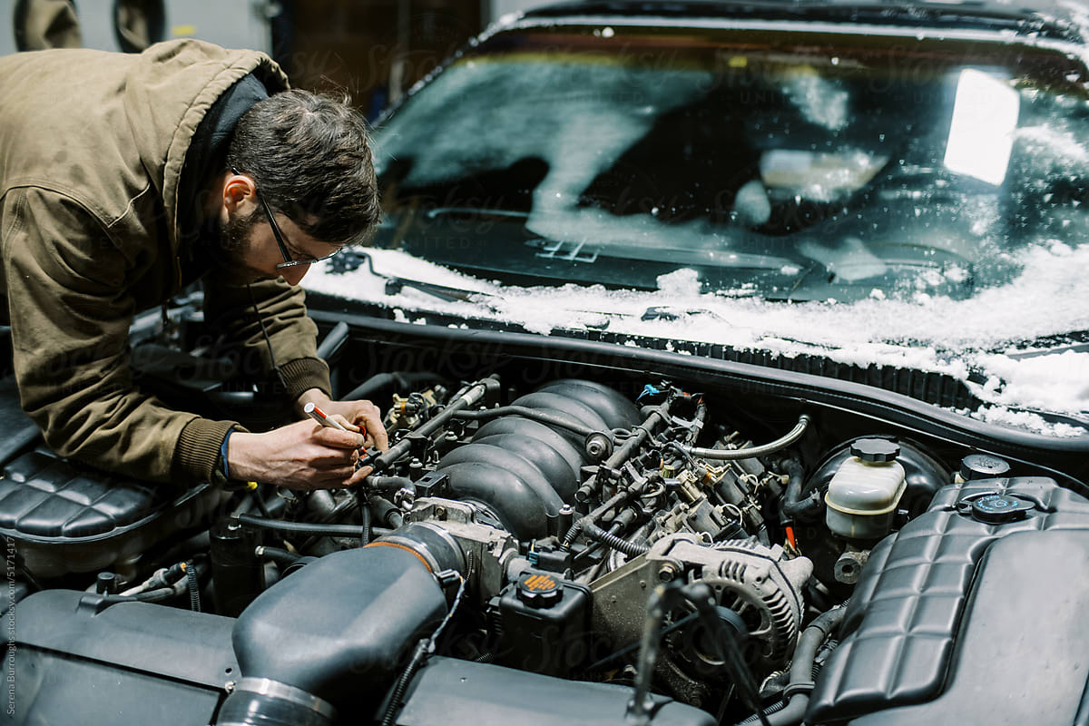 Millennial Mechanic working in engine bay of a car