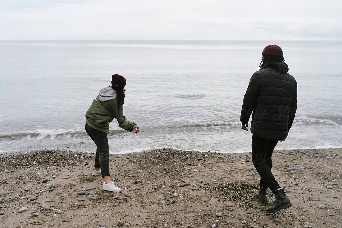 Couple Throwing Pebbles on the Beach